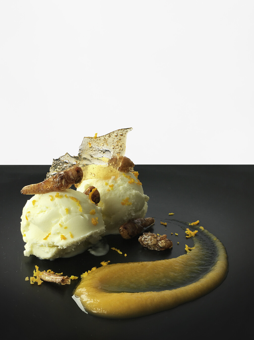 Olive oil ice cream, orange sauce, caramelized grasshoppers, orange zest.   